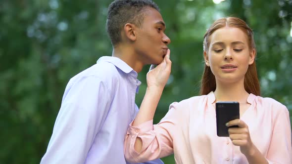 Teenage Girl Chatting Smartphone Rejecting Mixed-Race Boyfriend Kiss, Addiction
