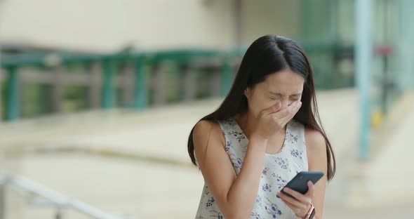 Woman use of mobile phone and sudden sneeze