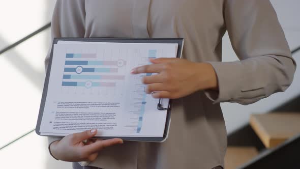 Unrecognizable Hands Holding Clipboard With Printed Diagram