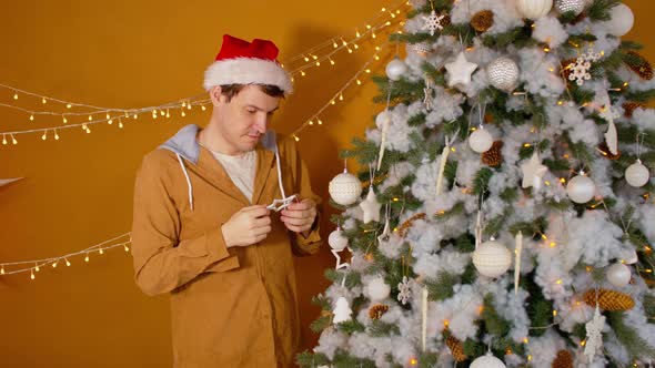 Man in Santa Hat Decorating Christmas Tree