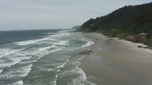 Slow wide drone tracking shot of expansive ocean beach