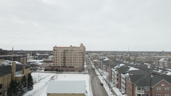 Aerial view toward downtown area in winter. Large housing complex and park.