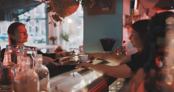 Waitress taking cake and glass from the counter