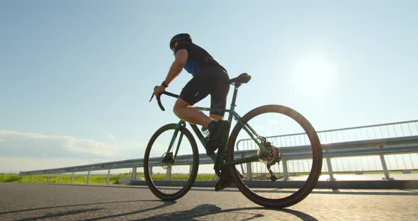 A Sportsman on a Bicycle is Standing on the Pedals and Developing Great Speed