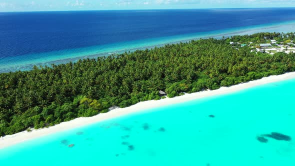 Daytime birds eye travel shot of a sandy white paradise beach and blue ocean background in colourful