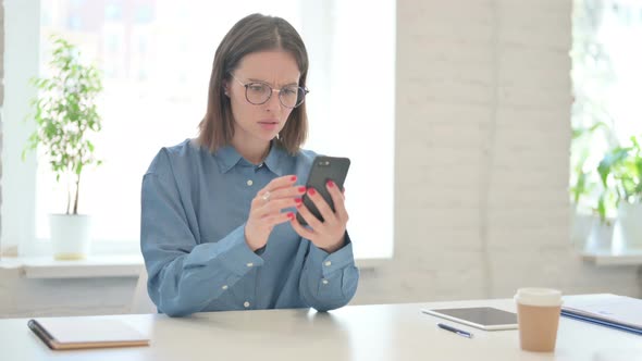 Young Woman Reacting to Loss on Smartphone