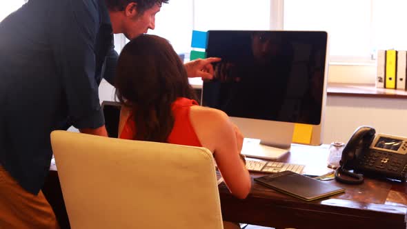 Male and female graphic designers interacting while using graphics tablet