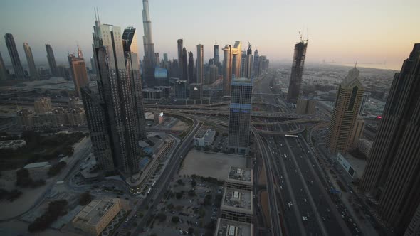 Slow Tilt View of Metropolitan Dubai City Center with Tall Skyscrapers and Busy Multi Lane Highway