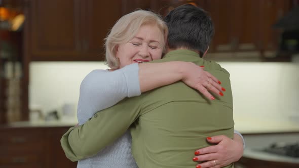 Portrait of Excited Senior Woman Hugging Adult Man Looking at Camera with Happy Facial Expression