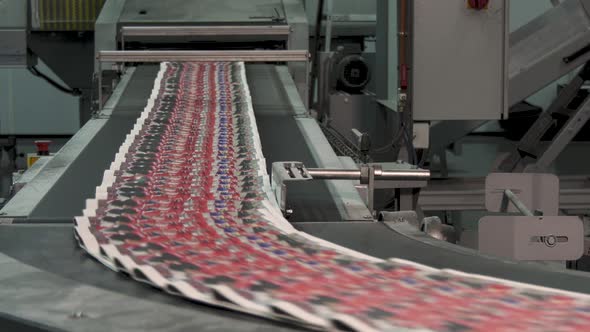 Printed newspapers moving on conveyor at high speed in printing factory