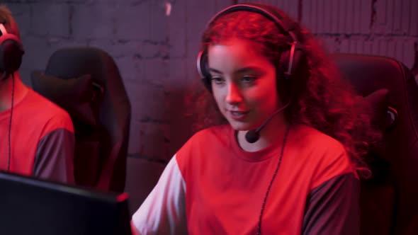 Young Gamers in Headphones Plays a Video Game Cyber Sportsman at the Game Communication Between