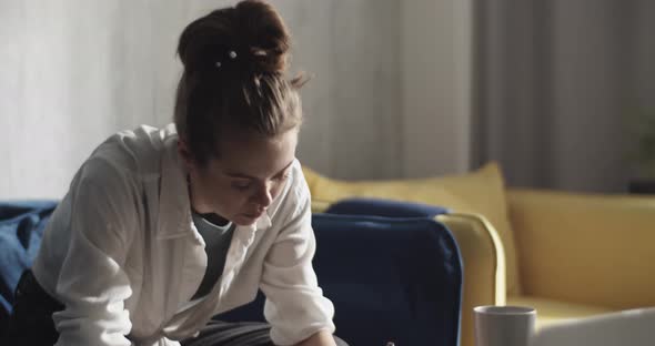 Focused Female Student Taking Notes and Doing Homework