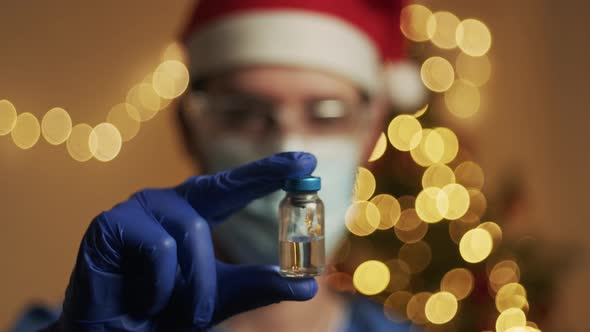 Doctor with vaccine on Christmas Background