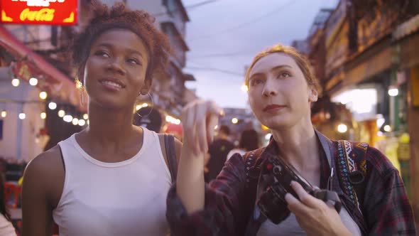 Two girlfriends are enjoying a night out on Yaowarat Road or Chinatown in Bangkok, Thailand.