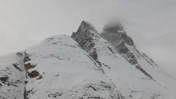 Aerial drone shot rotating around snow covered Otertinden mountain in Troms, Finnmark. Northern Norw