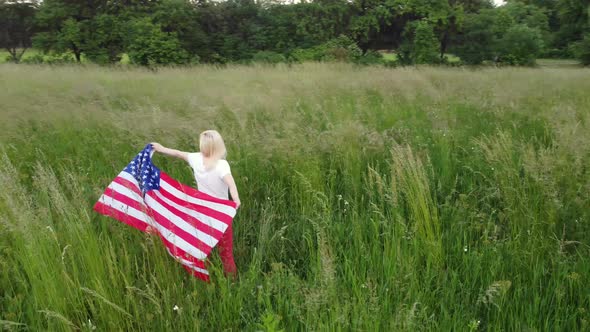 Full Length Blond Woman Holding American Flag in Trees Shadow of Sunlight Back View Cute Blondy Girl