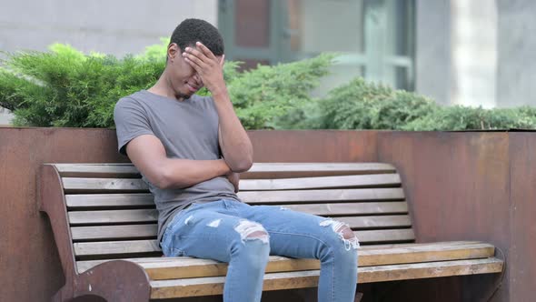 Worried Young Young African Man Sitting on Bench and Thinking 