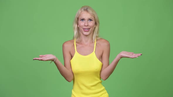 Young Beautiful Blonde Woman Shrugging Shoulders