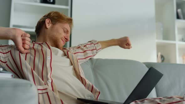 Tired Guy Browsing Web at Home Office Closeup