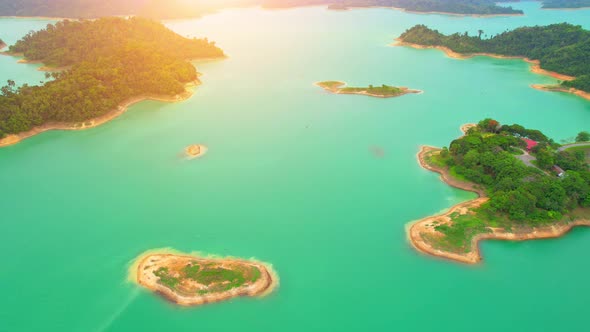 A drone flying over a dam in a beautiful tropical forest.