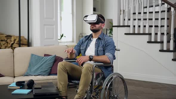 Man in Wheelchair which Working on Imaginary Screen Using Virtual Reality Headset