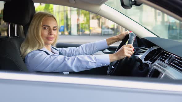 Portrait of a Confident 50 Years Woman Sitting in a Car in a Business Suit Near a Modern Office