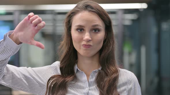 Portrait of Thumbs Down Gesture by Young Businesswoman