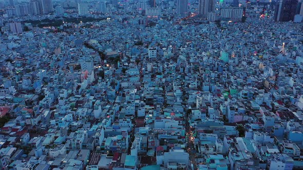 drone shot tracking from left to right at twilight over densely populated and built up area of a mod