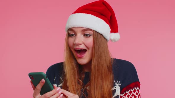 Woman in Stylish Christmas Sweater Looking Smartphone Display Sincerely Rejoicing Win Success Luck