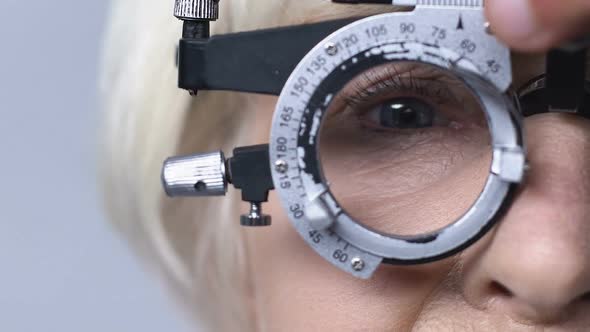 Eye Doctor Changing Lenses in Phoropter, Checking Mature Patient Vision, Closeup