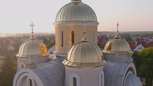 Bright Ukrainian Church in the Country with Golden Domes and Bell Tower