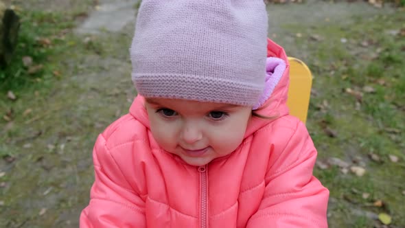 Cheerful toddler girl  playing at children playground. Slow motion.