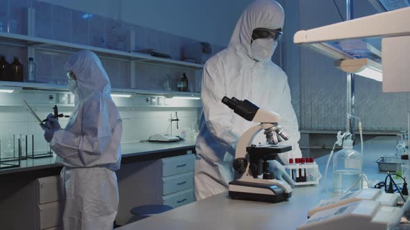 Epidemiologist Using Microscope in Lab