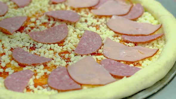 Cook Prepares Pizza with Bacon and Smoked Sausage Adds Slices of Bacon