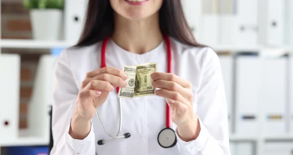 Woman Doctor Folding Dollar Bill and Putting in Uniform Pocket Closeup  Movie Slow Motion