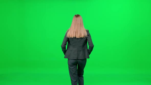 Businesswoman in a Suit Walking Down the Street on a Green Background a Passerby on a Walk Chroma