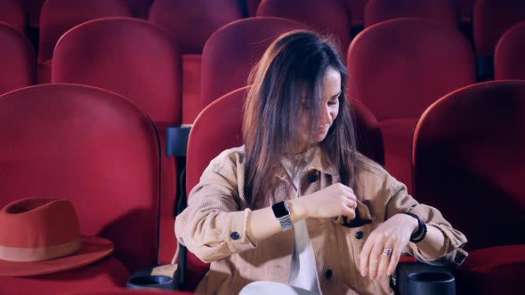 Girl Prepares to Watch a Movie at the Cinema