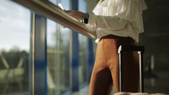 The Woman at the Airport Window Looking at the Runway Waiting for Landing Airplane Closeup alt