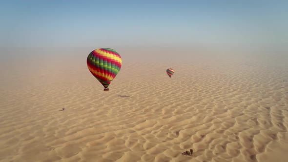 Aerial view of hot-air-balloon flying in the clouds on desert in Dubai, U.A.E.