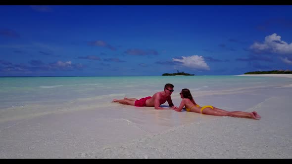 Romantic couple engaged on luxury island beach holiday by shallow lagoon and white sand background o