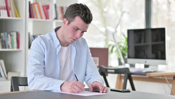 Young Man Writing Documents Doing Paperwork