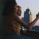 Girls taking pictures out of balcony with smartphone and smiling - VideoHive Item for Sale
