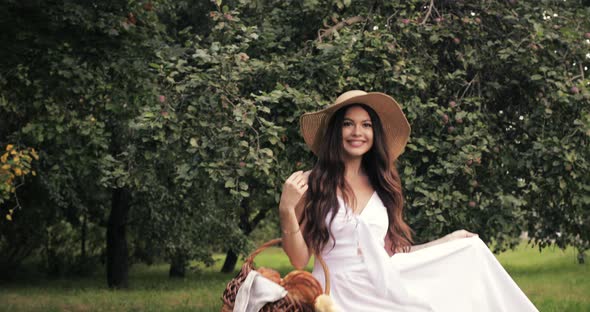 Happy Young Woman in a Straw Hat Walking Ahead