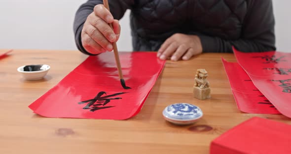 Man write chinese calligraphy for lunar new year