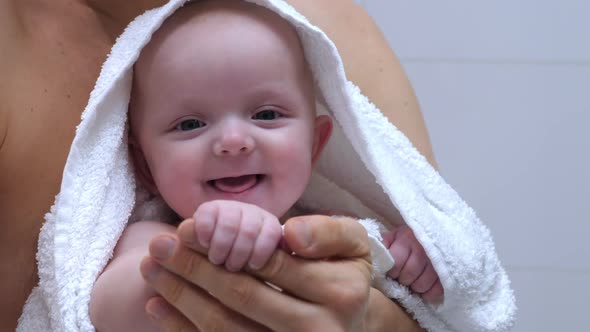 Father Holding Baby In Towel After Bath. Baby Girl Holding Daddy By Hand. 