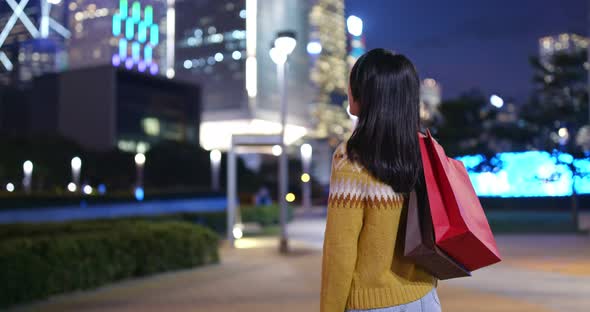 Woman Use of Smart Phone and Holding with Shopping Bag at Night