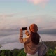 Young woman traveler taking photo with smart phone at sea of mist - VideoHive Item for Sale