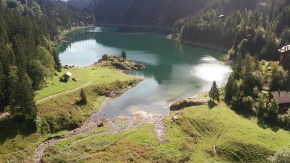 Aerial of stunning lake, tilting up to beautiful mountain in Switzerland