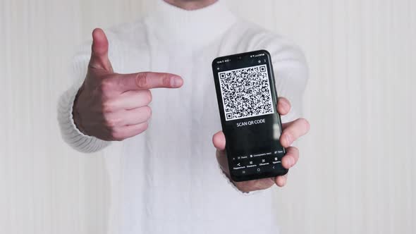 Man Shows QR Code on Smartphone and Shows ThumbsUp Sign on White Background