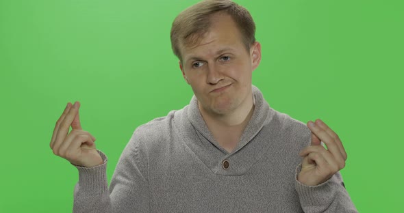 Handsome Young Man in Sweater Doing No Money Gesture. Poverty. Chroma Key